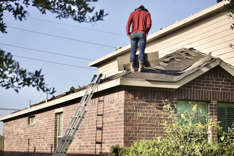 Professional roofer working on a residential roof in Tudor Village